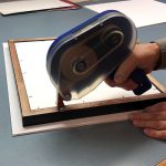 Pro® 154 ATG being adhered to the back of the frame for backing paper. Pro® 154 ATG being adhered to the back of the frame for backing paper.
